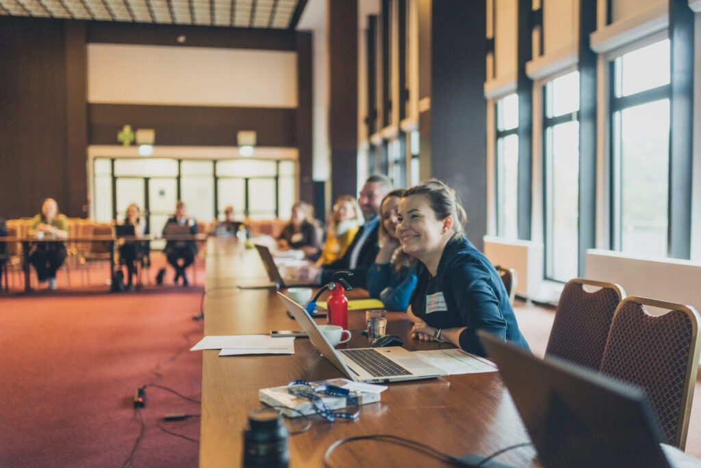 The project partners seat at the long table, discussing the progress of AIMused.